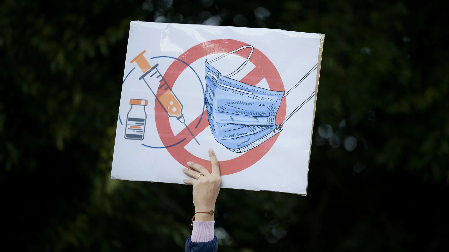 A woman holds a banner during an anti-government and anti-restrictions protest organised by the far-right Alliance for the Unity of Romanians or AUR, in Bucharest, Romania, Saturday, Oct. 2, 2021. Thousands took to the streets calling for the government's resignation, as Romania reported 12,590 new COVID-19 infections in the past 24 hour interval, the highest ever daily number since the start of the pandemic.