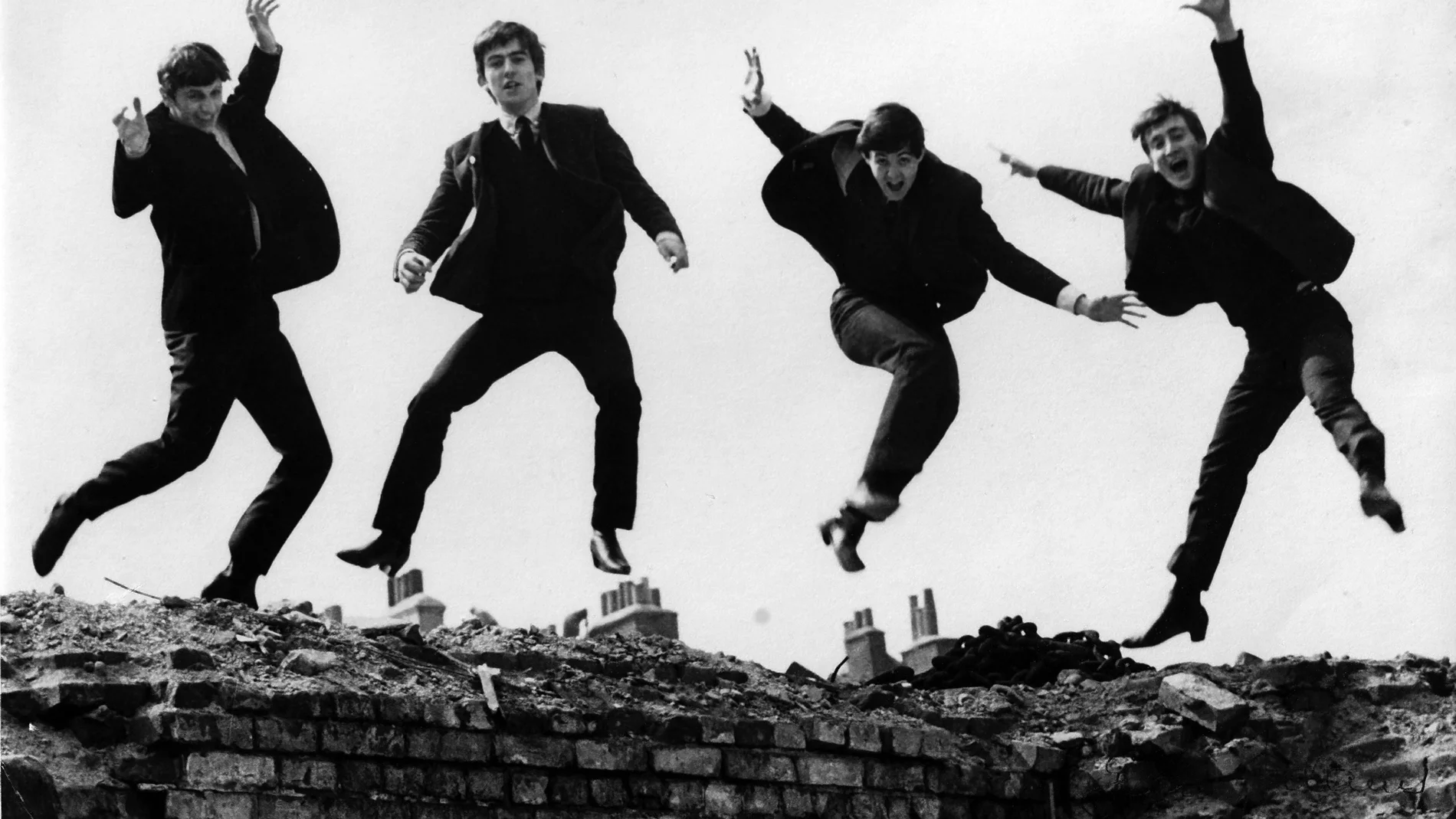 Photo of BEATLES; L-R: Ringo Starr, George Harrison, Paul McCartney, John Lennon - posed, group shot - jumping on wall, Used on the Twist & Shout EP cover