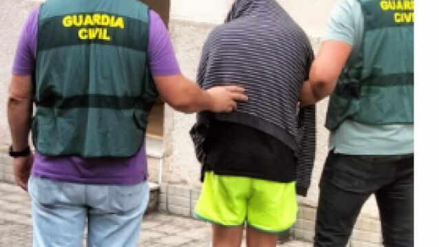 Dos agentes de la Guardia Civil conducen al detenido