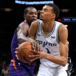 Wembanyama trata de superar la defensa de Kevin Durant