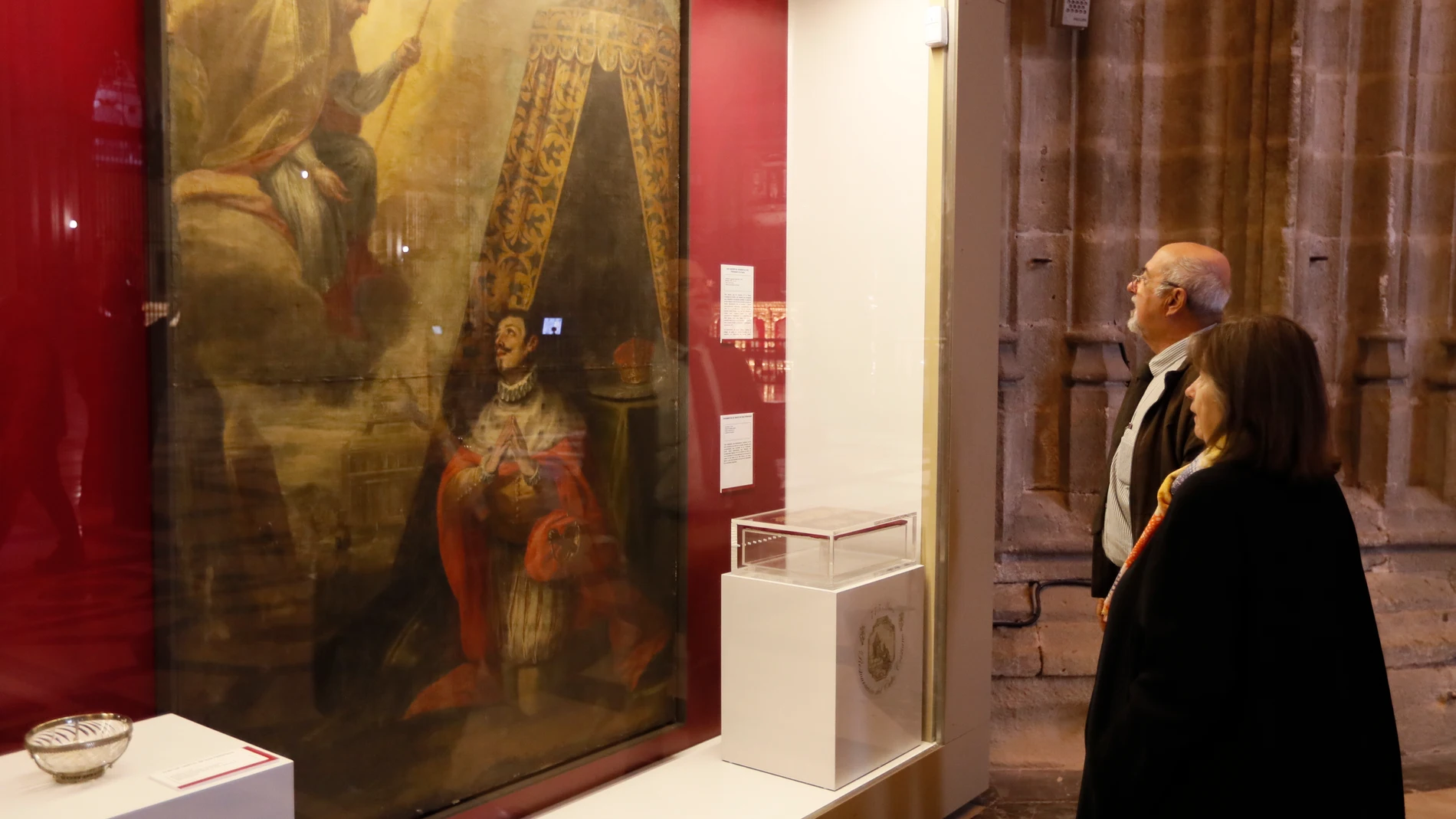 SEVILLA, 03/11/2023.- Dos personas observan el cuadro "San Isidoro se aparece al rey Fernando III El Santo" que forma parte de la exposición "San Fernando, el que más temie a Dios" que conmemora el 775 aniversario de la reconquista de la ciudad por el rey San Fernando y la restauración del culto cristiano, organizada por el Cabildo de la Catedral de Sevilla. EFE/José Manuel Vidal