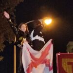 Isabel Peralta realizando el saludo romano y sosteniendo una bandera con la Cruz de Borgoña