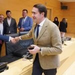 El consejero Juan Carlos Suárez-Quiñones saluda a los procuradores antes de comparecer en las Cortes