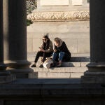 Dos jóvenes miran su móvil en El Retiro
