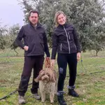 Raquel y Fernando posan con su perro de agua Lucas en la plantación de encinas ecológicas que tienen en Canalejas de Peñafiel
