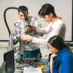 Trabajo en equipo de clase de robótica de ingeniería por parte de jóvenes estudiantes