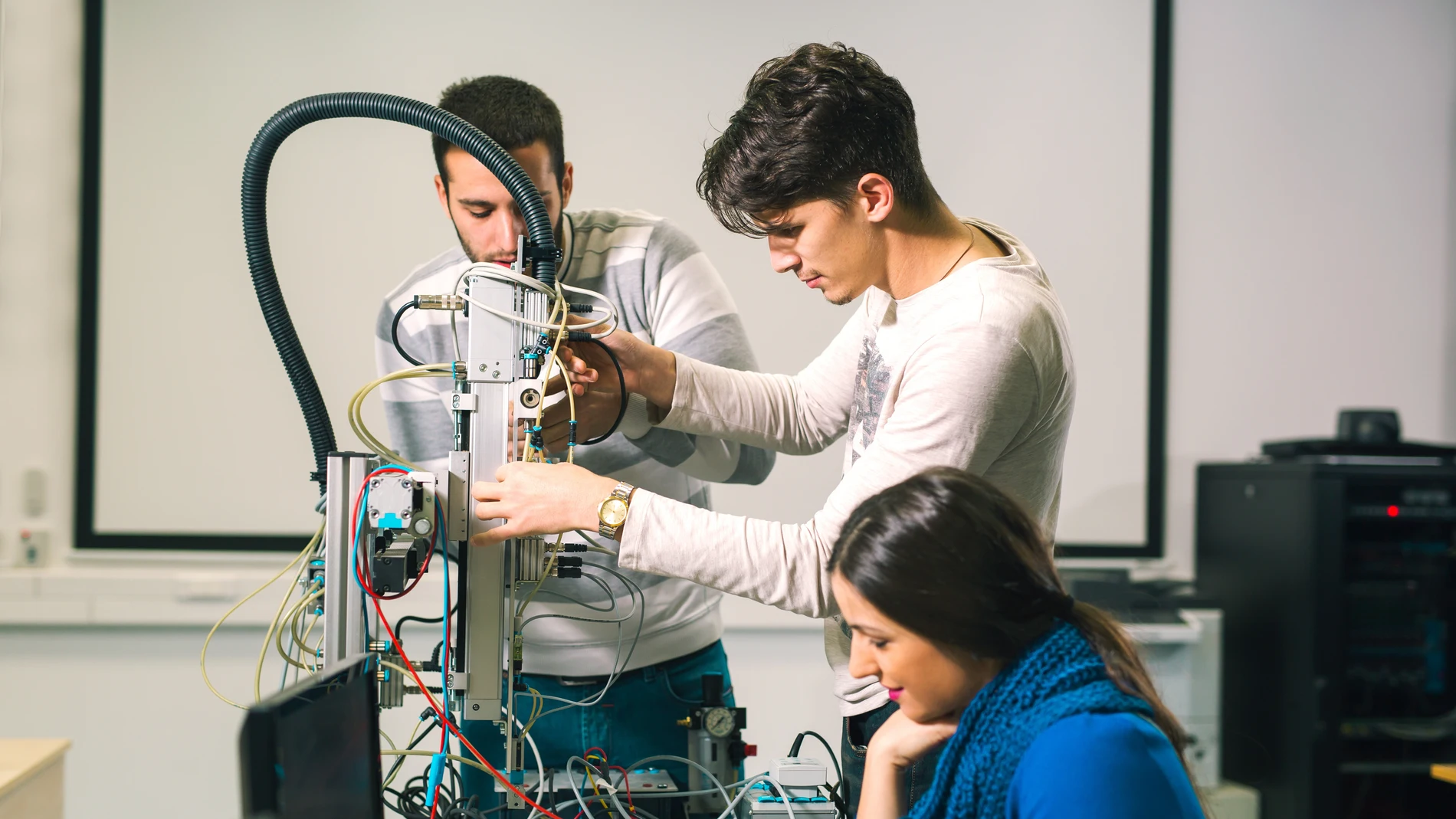 Trabajo en equipo de clase de robótica de ingeniería por parte de jóvenes estudiantes