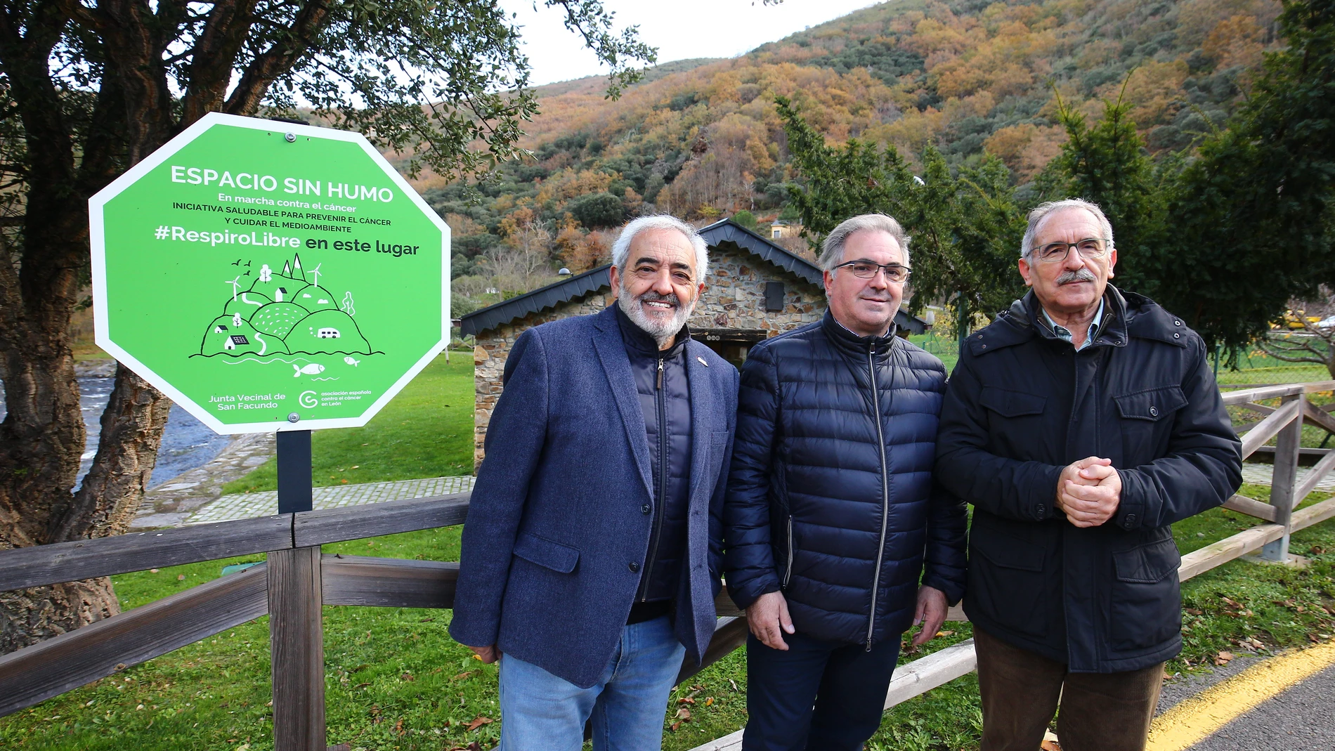 El presidente de la Asociación Española Contra el Cáncer en León, Estanislao de Luis Calabuig (D), junto al miembro del Consejo, Ramón Villan (I), y el alcalde pedáneo de San Facundo (C), Ricardo Vila, durante la presentación de la localidad como ‘Espacio sin humo’