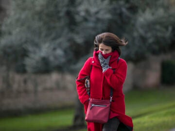 Una mujer se tapa del fr&iacute;o en Le&oacute;n