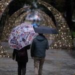 Imagen de archivo de una pareja paseando en Oviedo bajo la lluvia