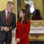 La Reina Letizia con traje rojo junto al Rey Felipe.