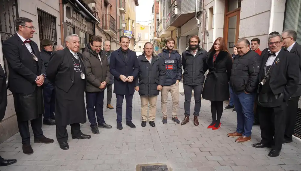Conrado Íscar, Roberto Díez, Yolanda Burgoa y Pablo Martín, entre otros, junto al bodeguero Tomás Postigo y dos de su hijos en la placa de su bodega en este paso del vino de Peñafiel