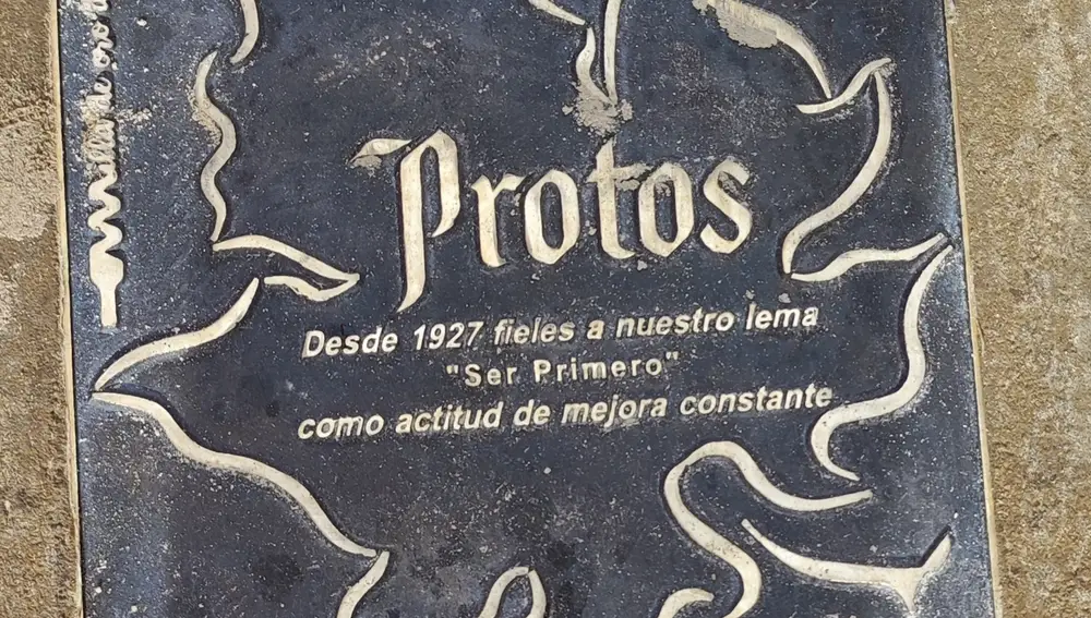 Ser primeros como actitud de mejora constante, lema de Protos que puede leerse en su placa