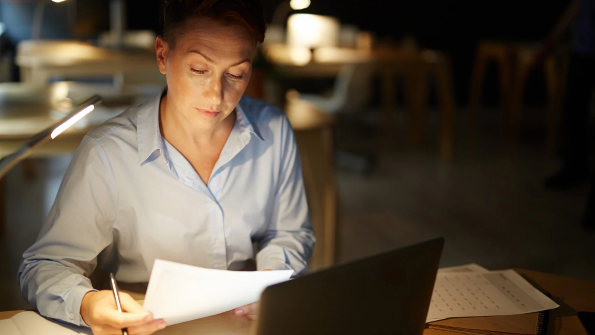 mujer trabajando oficina turno noche