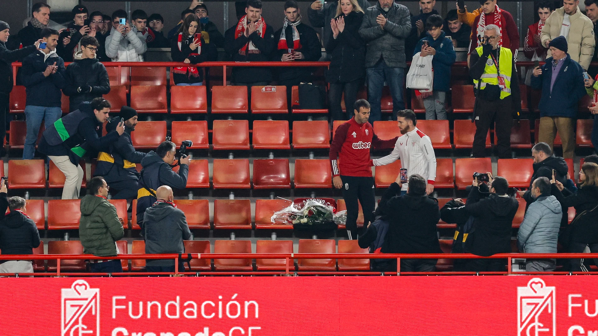 Victor Diaz of Granada CF and Iker Muniain of Athletic Club pay tribute to a Granada deceased fan with flowers and a jersey with his name and his membership number during the Spanish league, La Liga EA Sports, football match played between Granada CF and Athletic Club at Nuevo Los Carmenes stadium on December 11, 2023, in Granada, Spain. AFP7 11/12/2023 ONLY FOR USE IN SPAIN