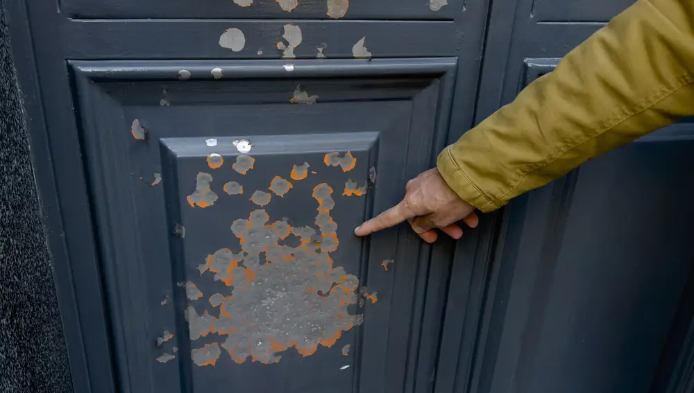 Puerta de una vivienda del barrio en la que se aprecia la ráfaga de disparos