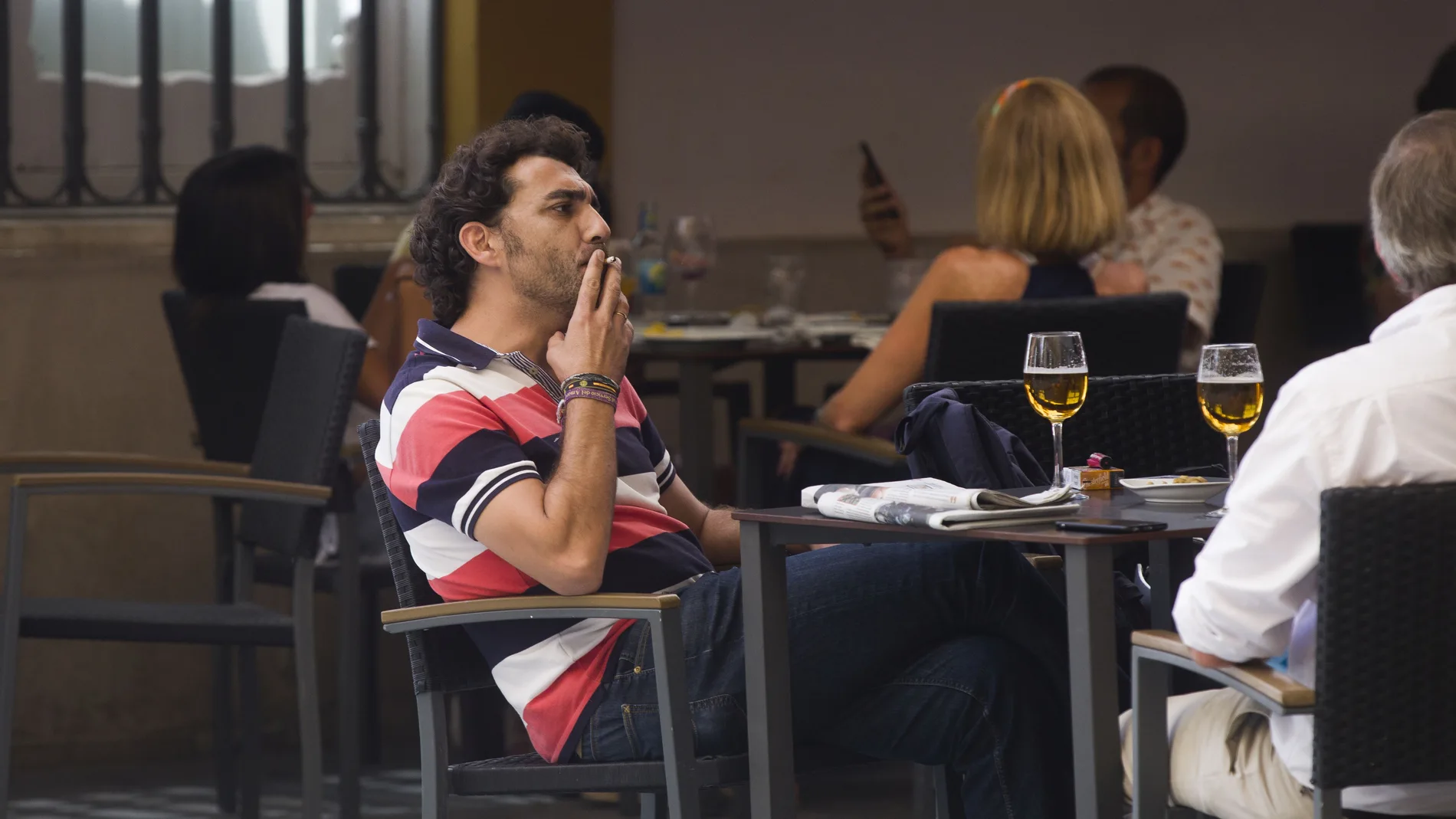 Un hombre fuma en la terraza de un restaurante