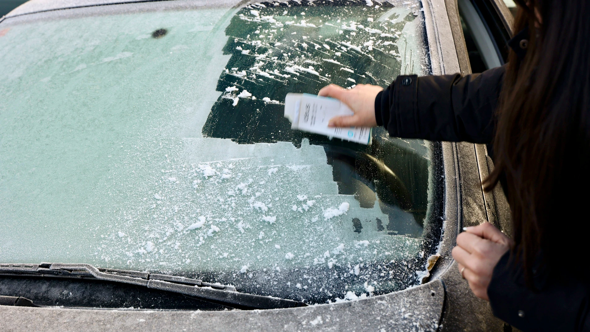 LOGROÑO, 18/12/2023.- Una mujer retira escarcha del parabrisas de un vehículo este lunes en Logroño. La Agencia Estatal de Meteorología (Aemet) prevé para este lunes en La Rioja intervalos de nubes bajas matinales en el valle, con brumas y bancos de niebla, así como un ascenso térmico en el nordeste de la península y niebla persistente en la Mancha y en la meseta norte, en donde bajarán las temperaturas. EFE/Raquel Manzanares