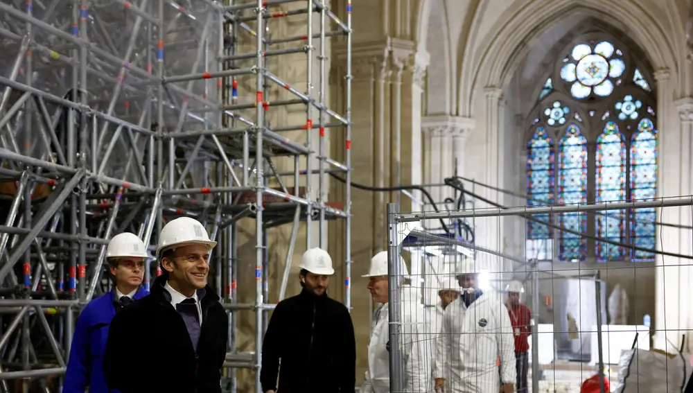 French President Emmanuel Macron (2L) walks inside the nave during a visit of the reconstruction work at the Notre-Dame de Paris Cathedral, on the Ile de la Cite in Paris.