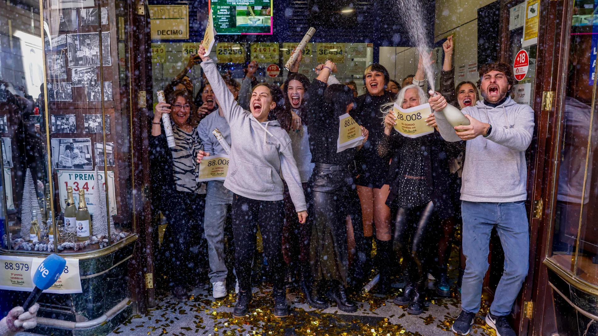 Varias personas celebran en la sucursal Doña Manolita de Madrid el Gordo del sorteo extraordinario de Navidad de la Lotería Nacional que ha recaído en el nº 88.008, este viernes. EFE/Aitor Martín