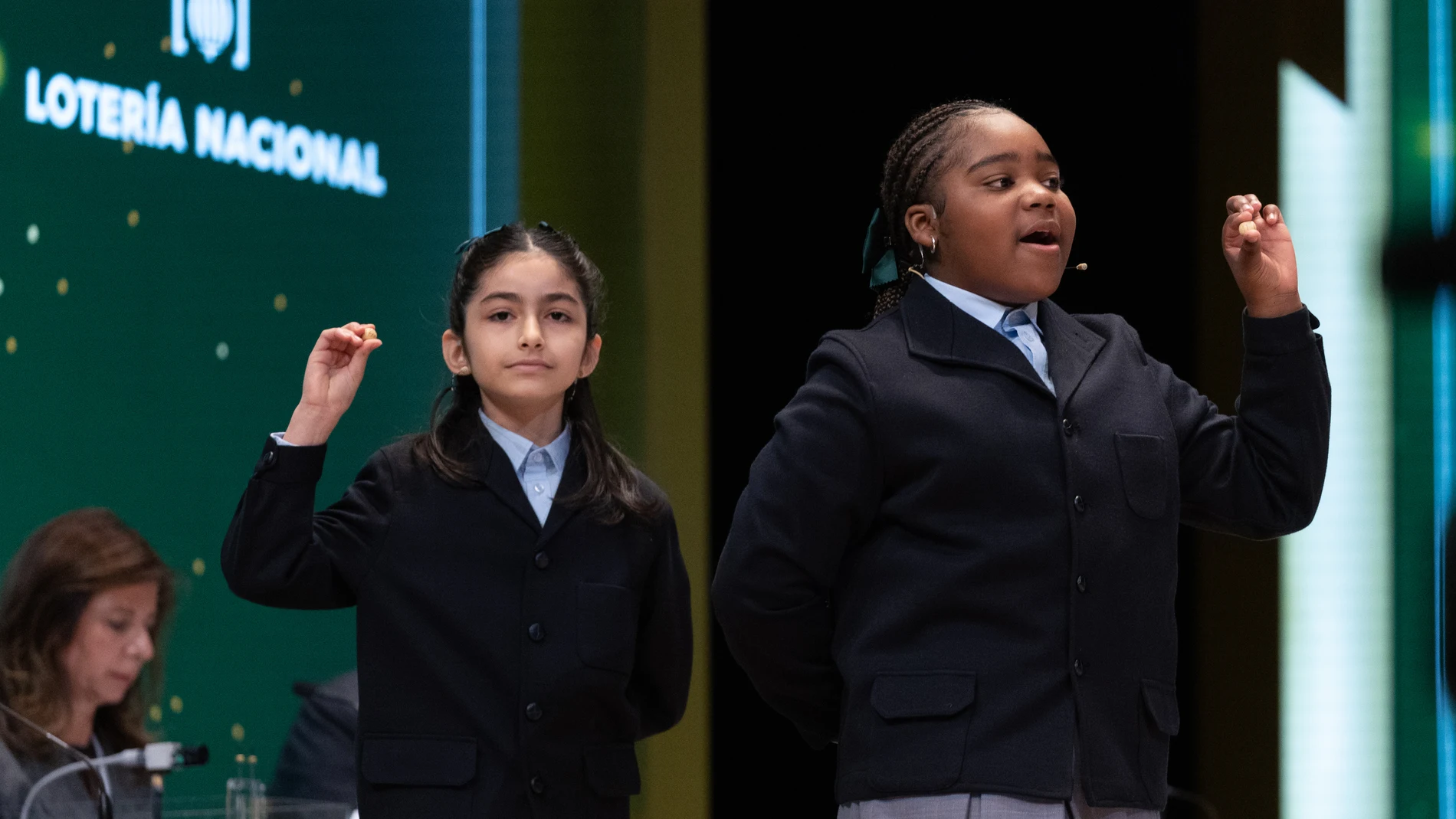 Rosario Martínez Garía (i), y Ainhoa Rosero Gómez (d) cantan un quinto premio, el número 37038, durante el Sorteo Extraordinario de la Lotería de Navidad 2023 en el Teatro Real de Madrid, a 22 de diciembre de 2023, en Madrid (España). Hoy se celebra el Sorteo Extraordinario de Navidad 2023, con el que el Estado reparte 2.590 millones de euros en premios entre los 185 millones de décimos de Lotería puestos a la venta. La emisión asciende a 3.700 millones de euros en total, repartiéndose en pre...