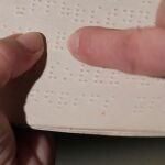 Lectura de una página en la exposición del Museo Tiflológico de la ONCE, en el sistema Braille.