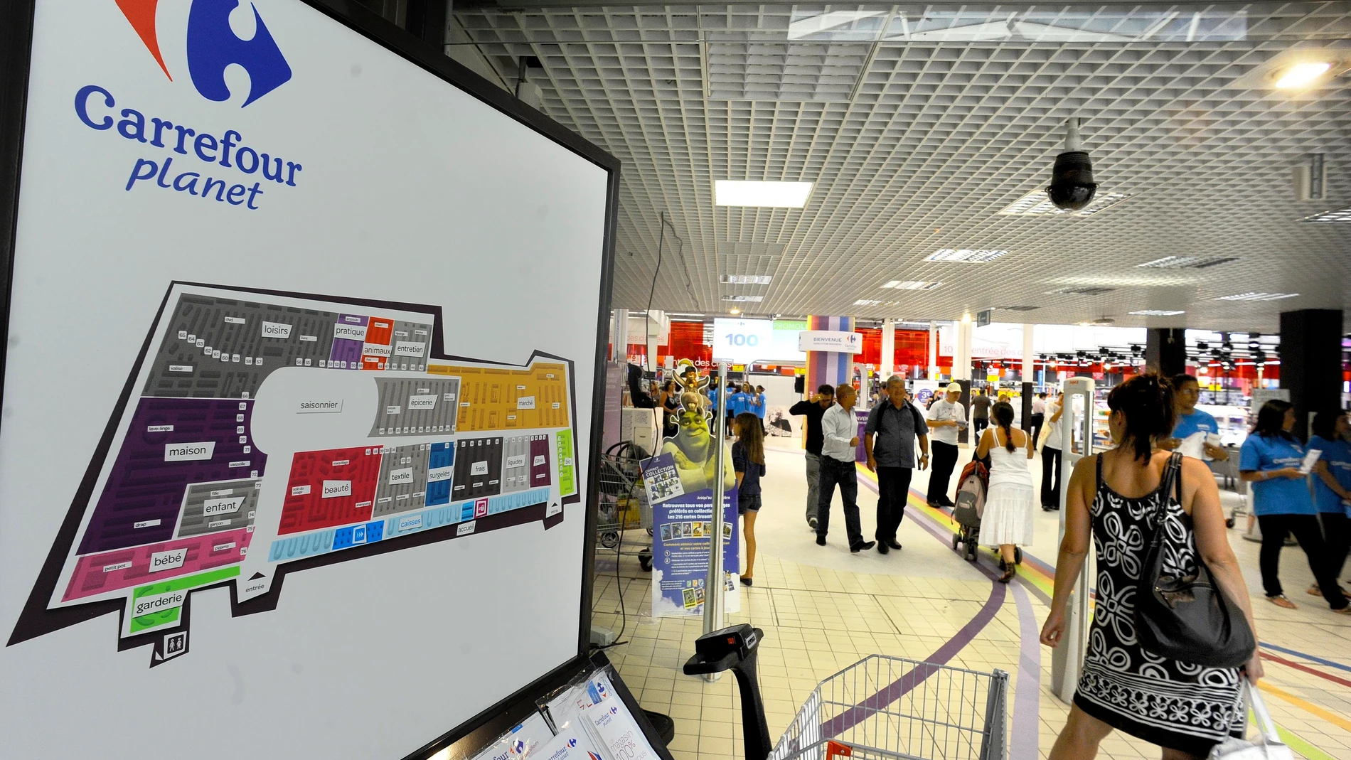 FILE - Shoppers enter the new Carrefour store Wednesday Aug. 25, 2010 in Ecully, near Lyon, central France. Carrefour has unveiled its hypermarket reinvention project at two stores in Lyon. The Ecully and Venissieux host the Carrefour Planet concept. The stores split into nine zones, including a 'discovery' store for events and seasonally themed products. (AP Photo/Thomas Campagne, File)