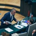 Momento en el que el portavoz de Vox en el Ayuntamiento de Madrid, Javier Ortega Smith, se encara y tira unos papeles y una botella de agua vacía al edil Eduardo Fernández Rubiño, concejal de Más Madrid, en su escaño. | Europa Press