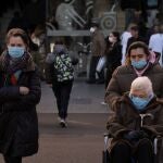 Varias personas con mascarilla a la salida de un hospital 