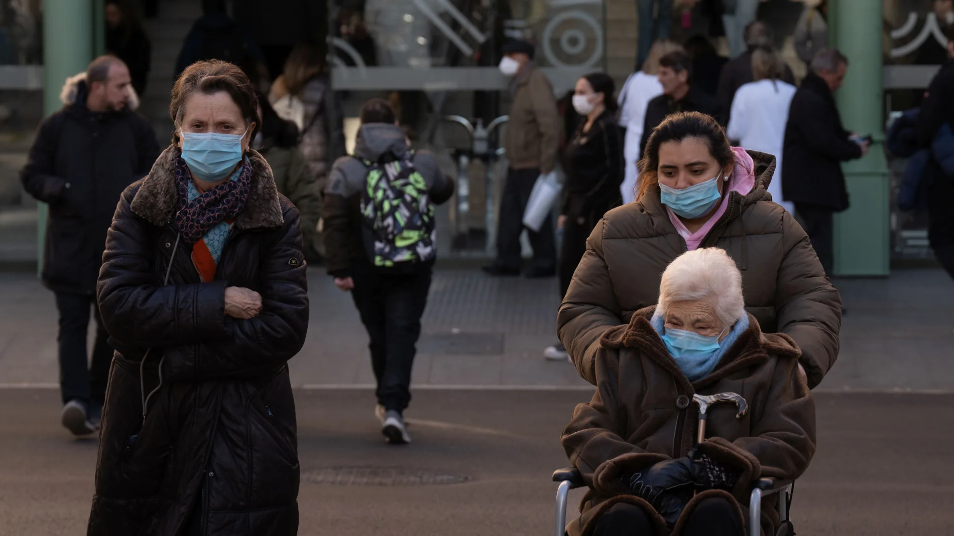 Varias personas con mascarilla a la salida de un hospital