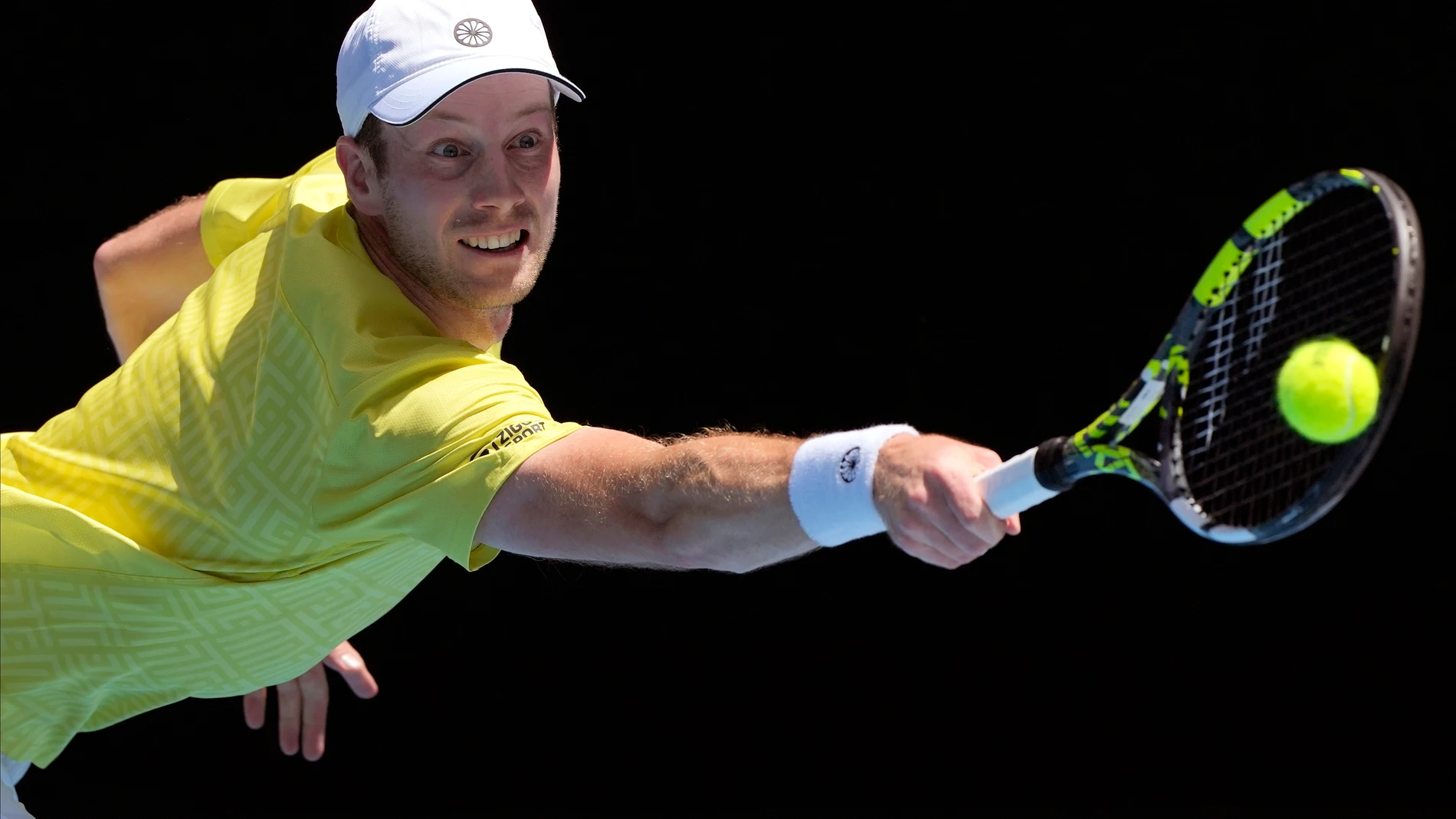 Botic van de Zandschulp of the Netherlands plays a backhand return to Italy's Jannick Sinner during their first round match at the Australian Open tennis championships at Melbourne Park, Melbourne, Australia, Sunday, Jan. 14, 2024. (AP Photo/Andy Wong)