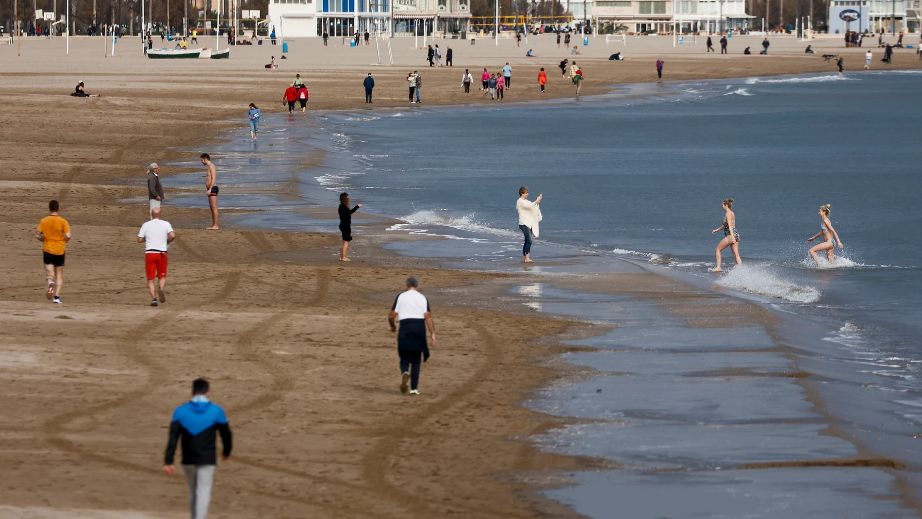 GRAFCVA7716. VALENCIA, 16/01/2024.- Varias personas disfrutan del buen tiempo en la playa de la Malvarrosa cuando la previsión en la Comunitat Valenciana es de cielo con intervalos nubosos sin descartar precipitaciones débiles y dispersas en el interior al final del día; temperaturas con pocos cambios, salvo ascenso de las máximas en la mitad sur; viento del oeste y del suroeste moderado, según la Agencia de Meteorología Estatal (Aemet). EFE/Biel Aliño