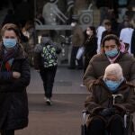 Personas con mascarilla a la salida de un hospital
