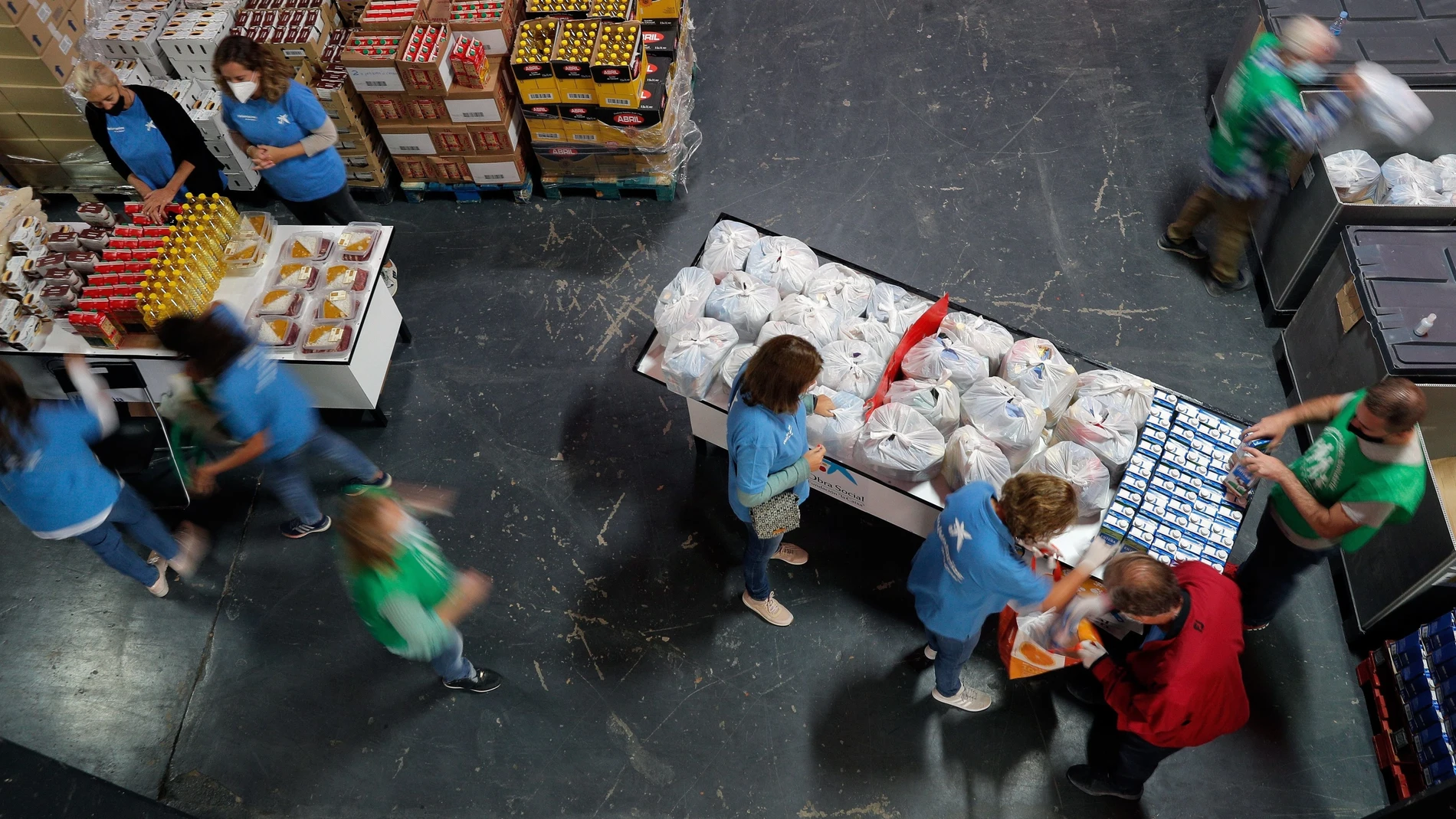 Varias personas recogen alimentos durante un reparto realizado por el Banco de Alimentos en el campo de Mestalla, Valencia.
