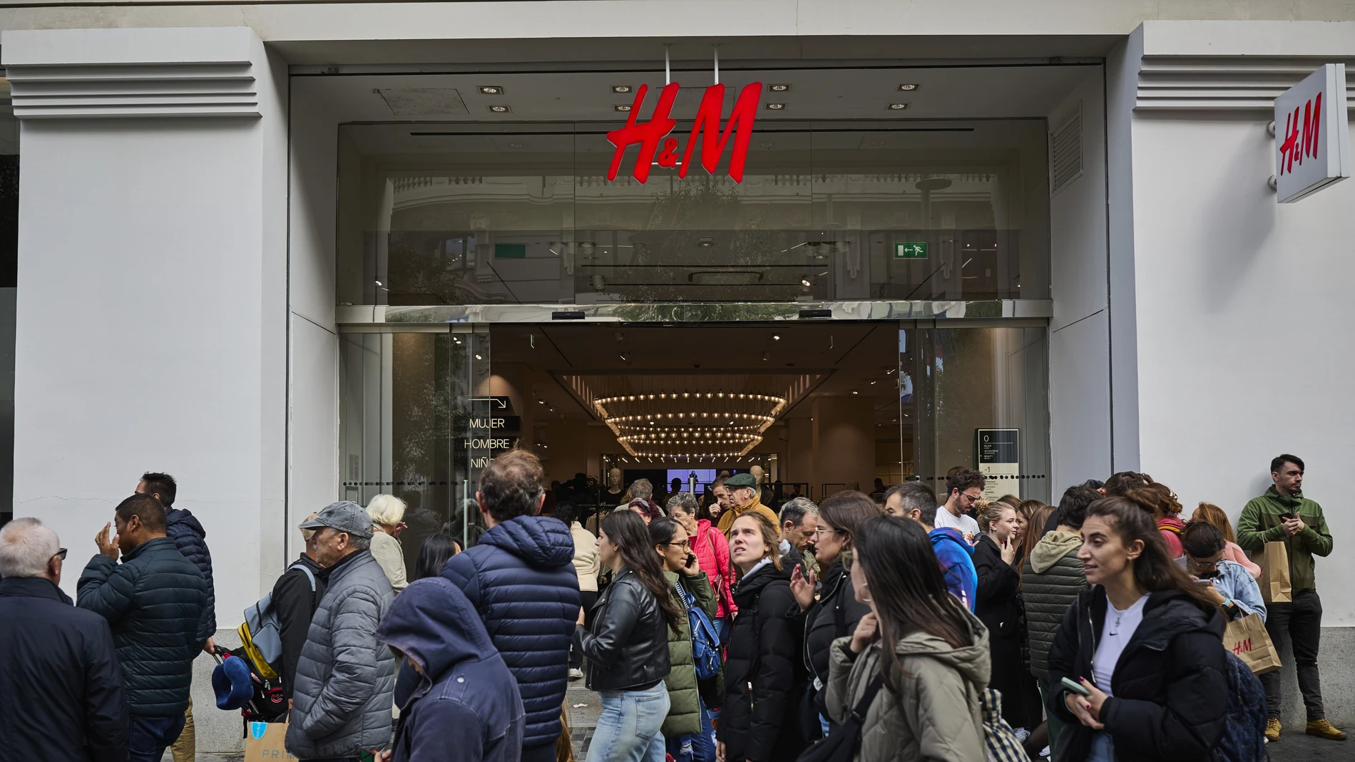 Gente comprando ropa en la cadena multinacional sueca de tiendas de ropa H&M