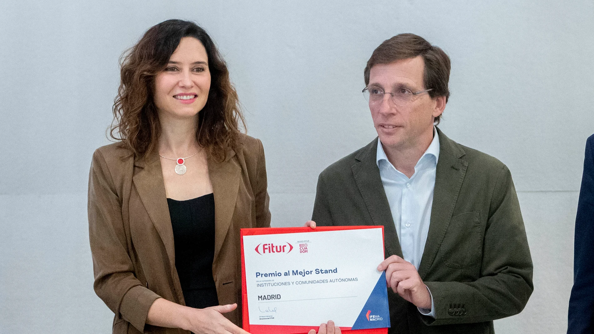 La presidenta de la Comunidad de Madrid, Isabel Díaz Ayuso, y el alcalde de Madrid, José Luis Martínez-Almeida, posan con el premio al mejor estand en Fitur 2024, en IFEMA Madrid, a 26 de enero de 2024, en Madrid (España). El stand de la Comunidad de Madrid es un espacio de casi 1.500 metros cuadrados de superficie, construido con materiales cien por cien reutilizables. En el diseño destaca una cubierta móvil formada por luminarias de diferentes colores que permite adecuar la luz y el ambient...