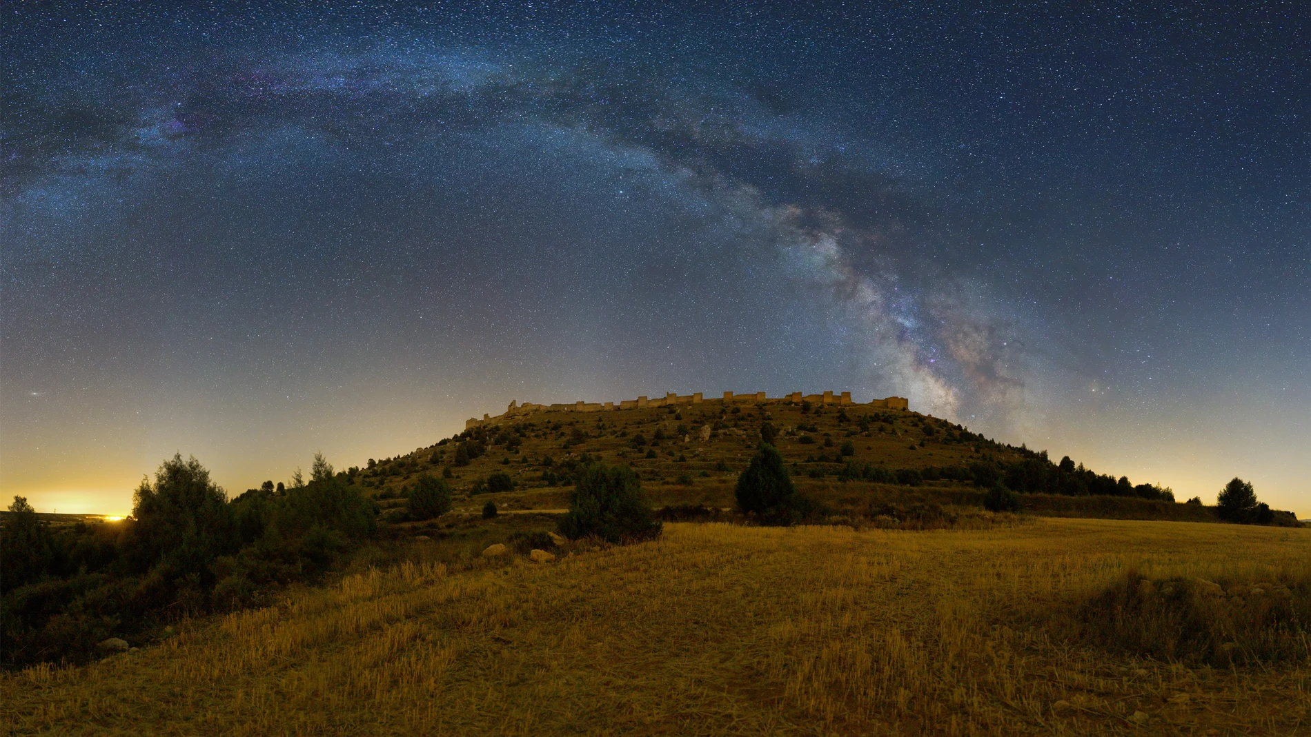 Imagen de la Vía Láctea sobre el castillo de Gormaz con el paisaje iluminado por la Luna