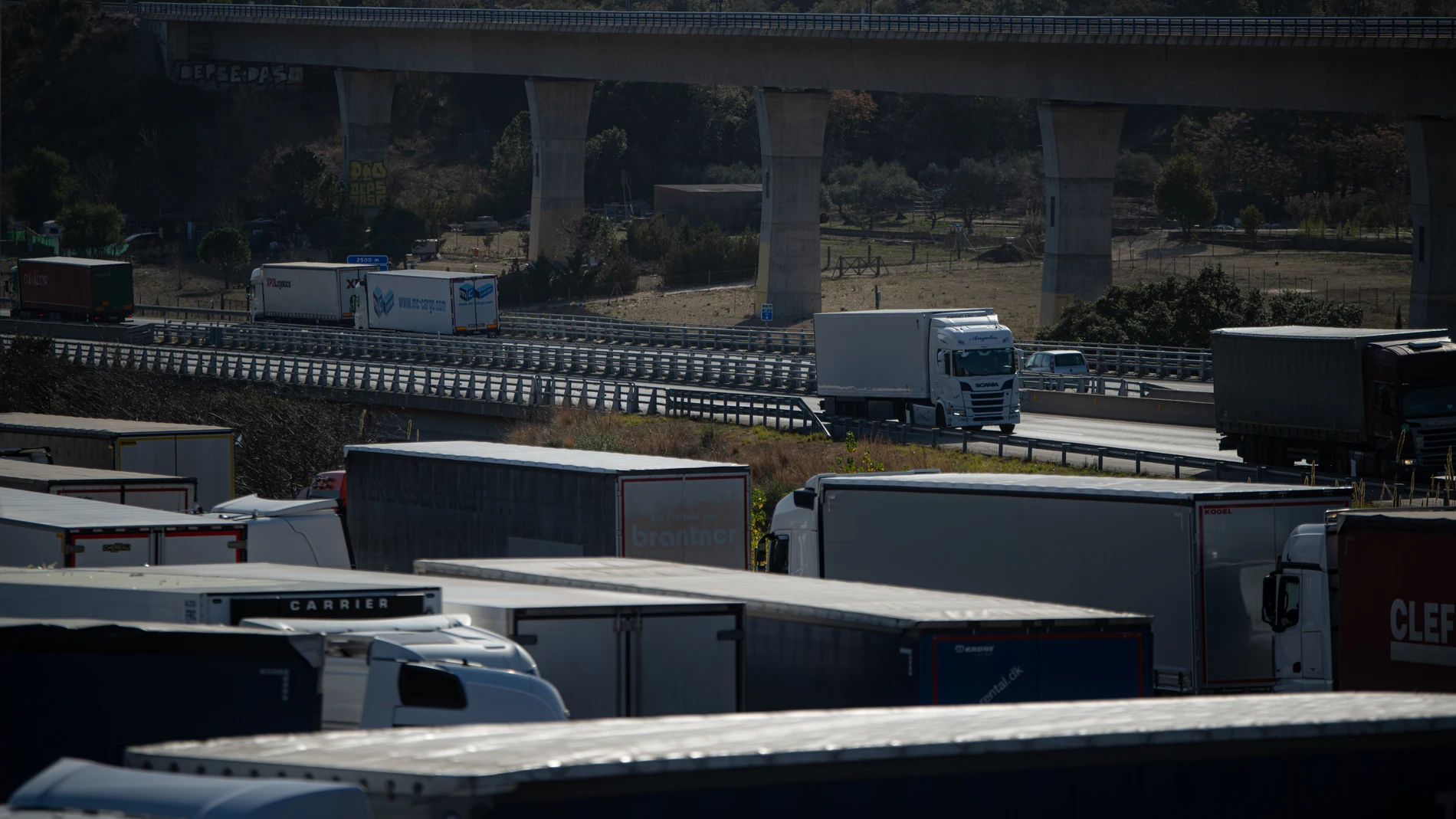 Varios camiones circulan, a 27 de enero de 2024, en La Jonquera, Girona, Catalunya (España). Se ha reabierto el tráfico en la A-9 francesa y la AP-7 española en la frontera entre Francia y España tras los cortes producidos ayer por las protestas de los sindicatos agrarios franceses. Estas protestas del sector agrario se han ido extendiendo por todo el país desde la semana pasada con bloqueos de carreteras y tractores, mientras la consigna del Gobierno es evitar la intervención policial para n...