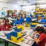 Personas con discapacidad trabajan en el taller de manipulados filatélicos para Correosde la fundación A LA PAR 