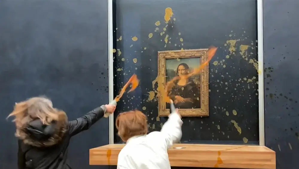 This image grab taken from AFPTV footage shows two environmental activists from the collective dubbed "Riposte Alimentaire" (Food Retaliation) hurling soup at Leonardo Da Vinci's "Mona Lisa" (La Joconde) painting, at the Louvre museum in Paris, on January 28, 2024.