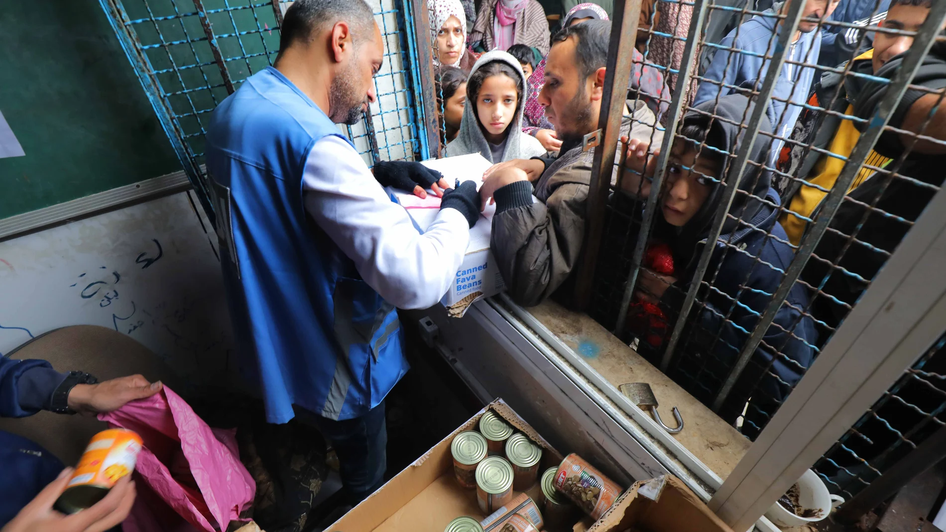 January 29, 2024, Dair El-Balah, Gaza Strip, Palestinian Territory: Displaced Palestinians live in a school run by the United Nations Agency for Palestinian Refugees (UNRWA) gather to get some aid in Deir al-Balah in the central Gaza Strip, on January 29, 2024 29/01/2024