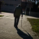 Mayores jubilados de la tercera edad pasean y toman el sol en un parque de Madrid.