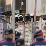 Mossos d'Esquadra vigilan a varios okupas de los edificios de La Ruïna y el Kubo en la plaza Bonanova de Barcelona. El juzgado de primera instancia número 39 de Barcelona, que lleva la demanda de desahucio del edificio de La Ruïna, una de las dos fincas ocupadas de la Plaza Bonanova de Barcelona, ha denegado las medidas cautelares en las que la Sareb pedía su desalojo inminente por cuestiones de seguridad. 