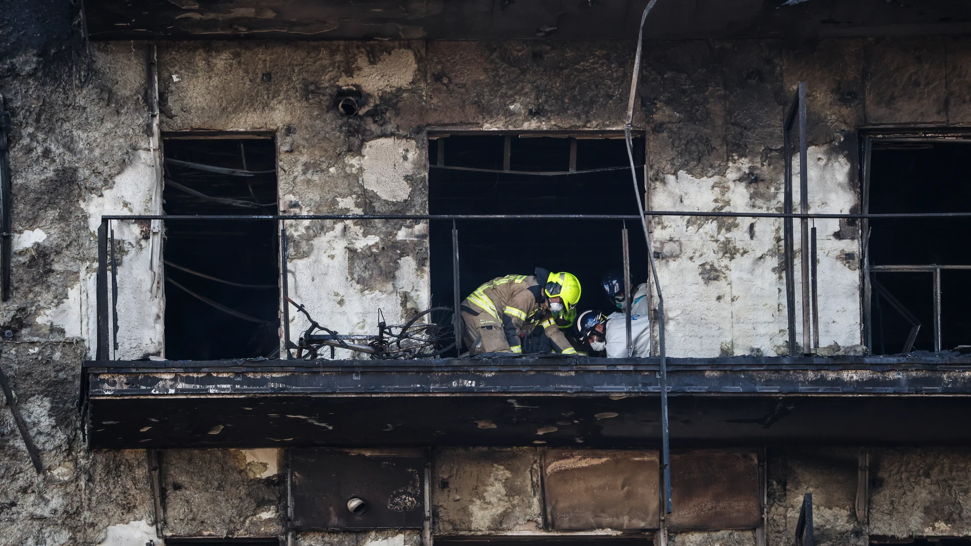 GRAFCVA8600. VALENCIA, 23/02/2024.- Bomberos y Policía Científica inspeccionan un cuerpo en un balcón del edificio incendiado en el barrio de Campanar de València. La cifra de víctimas mortales en el incendio se eleva a 10 tras la primera inspección ocular que han hecho en el interior de las instalaciones los bomberos y la Policía Científica. EFE/Miguel Ángel Polo