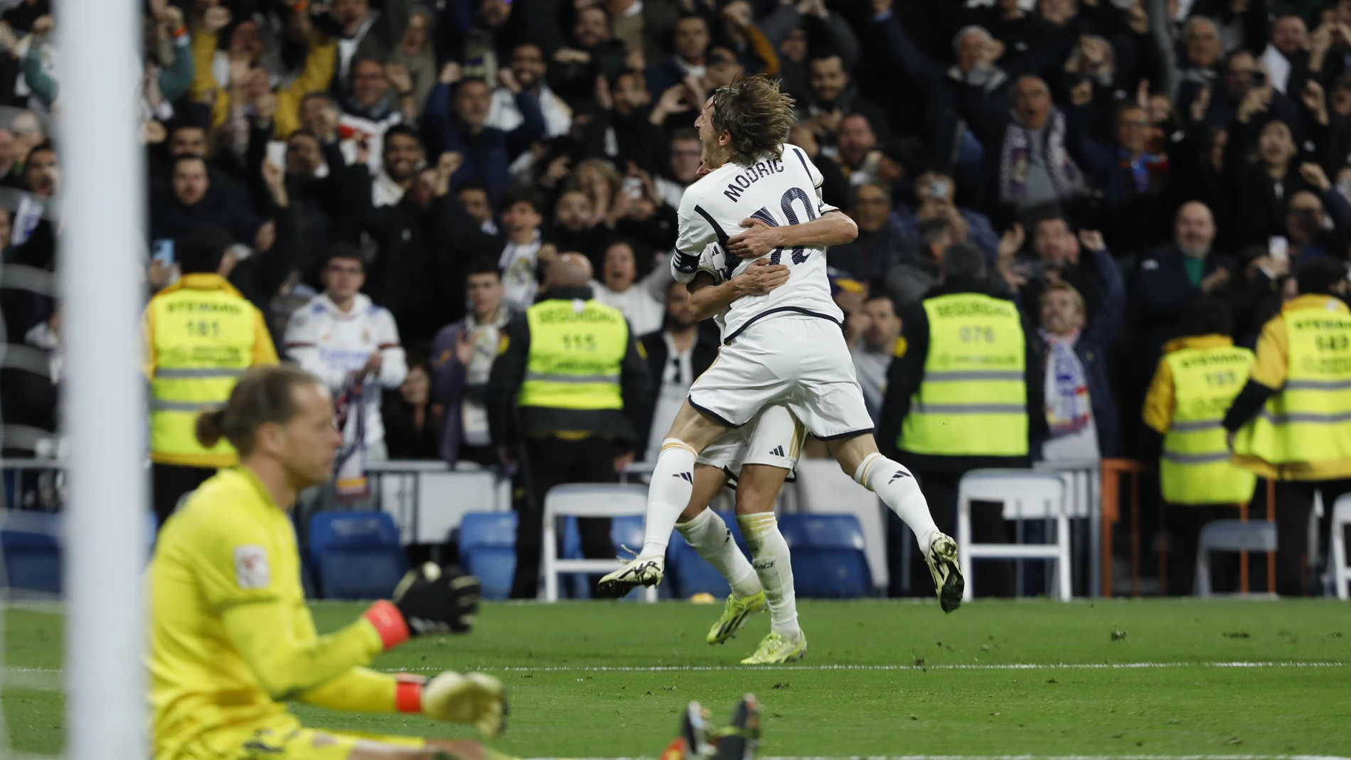 El centrocampista del Real Madrid Luka Modric (arriba) celebra tras marcar ante el Sevilla, durante el partido de Liga que Real Madrid y Sevilla FC disputan este domingo en el estadio Santiago Bernabéu.