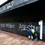 Trabajadora eliminando las pintadas de "asesinos" en la fachada del Estadio Municipal El Plantío (del Burgos CF)
