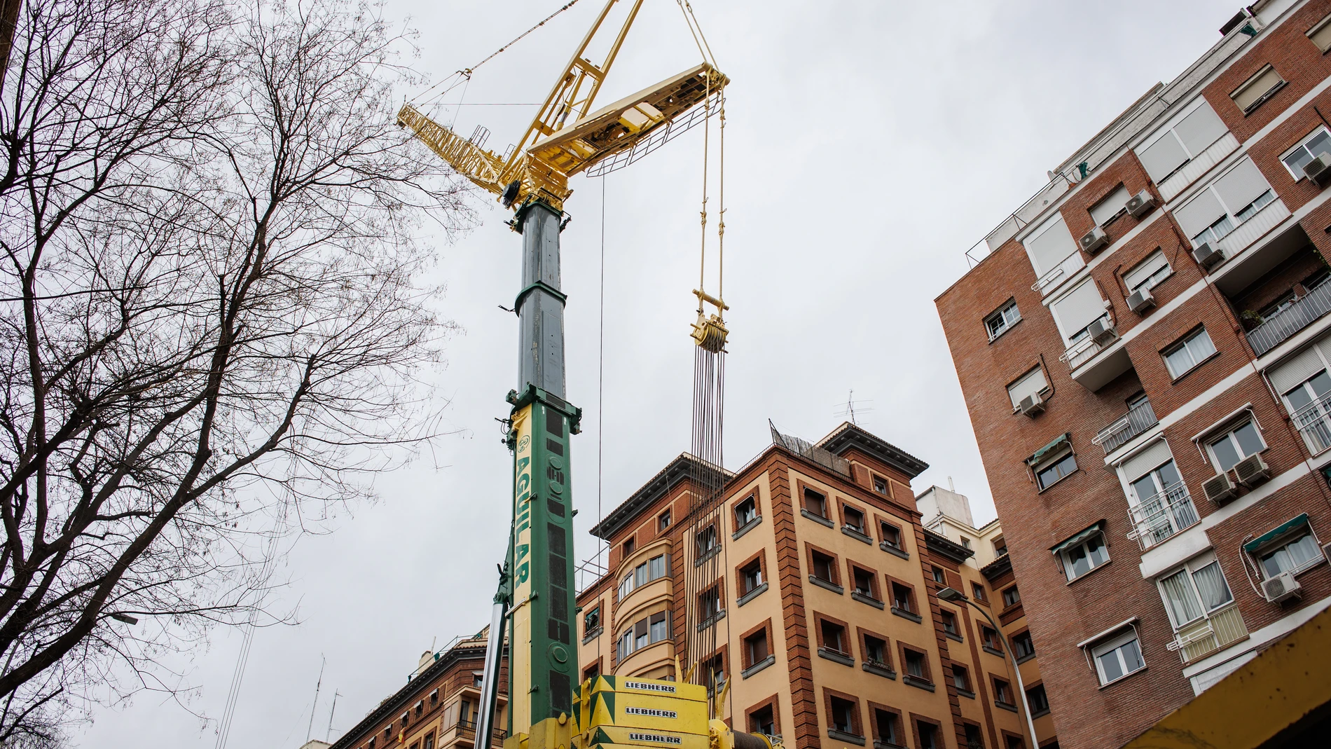 Una grúa junto a un edificio en la calle Cavanilles, a 2 de marzo de 2024, en Madrid (España). La vecindad de los números 25 y 27 de la calle Cavanilles, en el distrito de Retiro, está en pie de guerra contra una grúa "que pesa 60 toneladas", grande "como un tanque", que sobrevolará sus viviendas para la construcción de un parking en su patio de manzana, un proyecto que ya fue parado por el Ayuntamiento entonces gobernado por Manuela Carmena en 2018. Los vecinos destacan que nadie les ha cons...