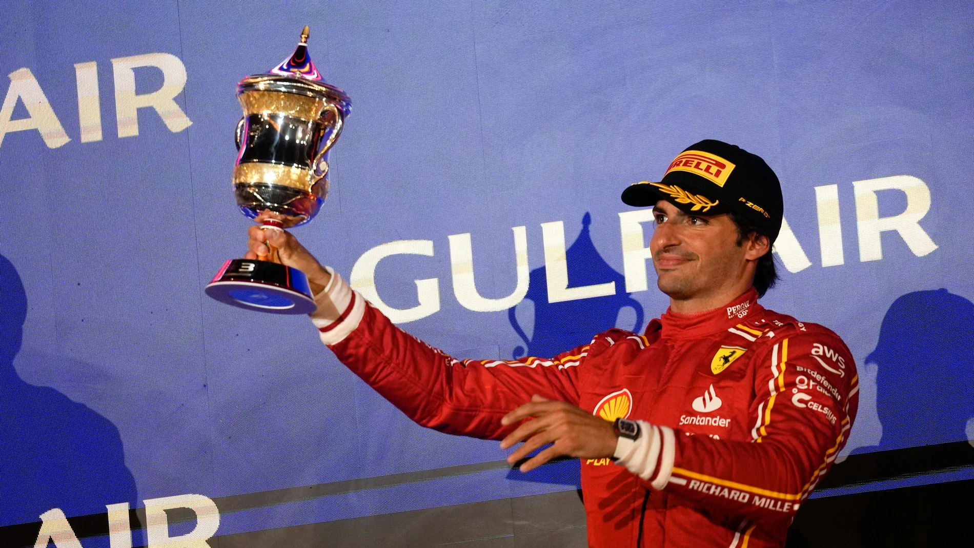 Third place, Ferrari driver Carlos Sainz of Spain holds up his trophy on the podium during the Formula One Bahrain Grand Prix at the Bahrain International Circuit in Sakhir, Bahrain, Saturday, March 2, 2024. (AP Photo/Darko Bandic)