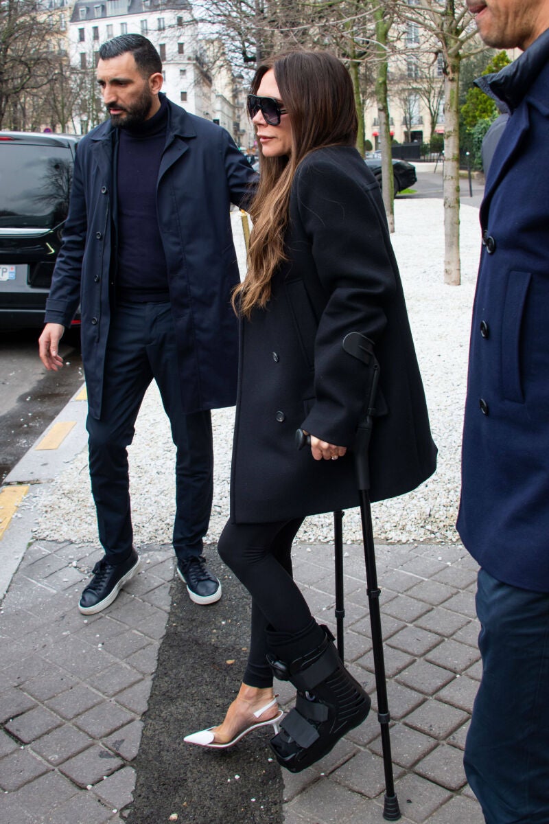 Victoria Beckham con tacones y muletas.