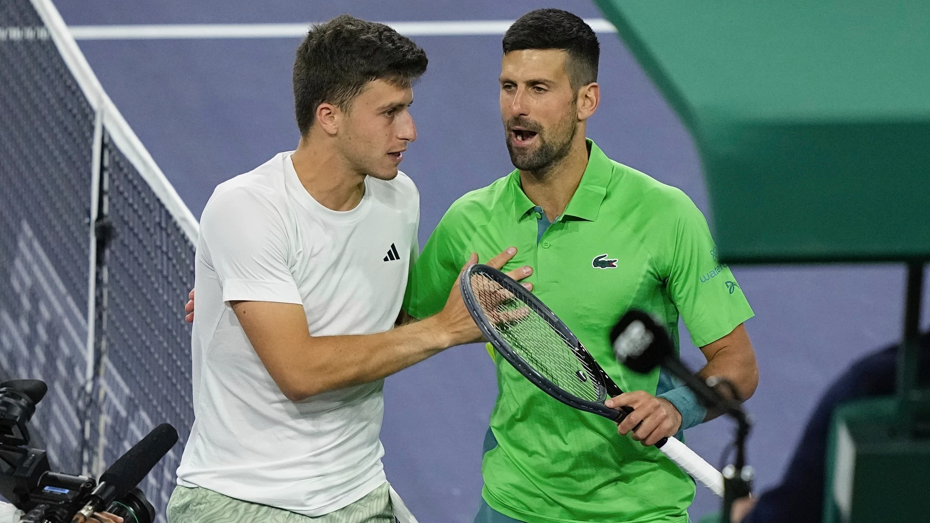 Luca Nardi, of Italy, talks with Novak Djokovic, of Serbia, after upsetting Djokovic at the BNP Paribas Open tennis tournament Monday, March 11, 2024, in Indian Wells, Calif. Nardi won 6-4, 3-6, 6-3. (AP Photo/Mark J. Terrill)